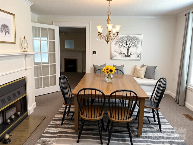 dining room featuring an inviting chandelier, dark carpet, visible vents, crown molding, and a fireplace