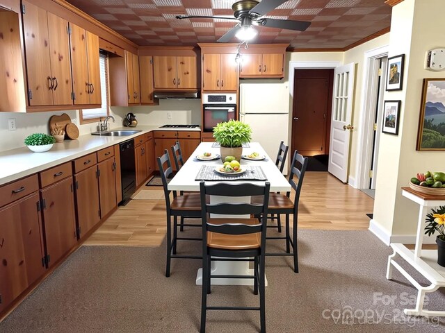 kitchen with a ceiling fan, a sink, white appliances, light countertops, and under cabinet range hood