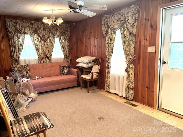 215 Old Dixie Rd, Lancaster, SC 29720 - living area with wood walls, carpet floors, a chandelier, and a ceiling fan