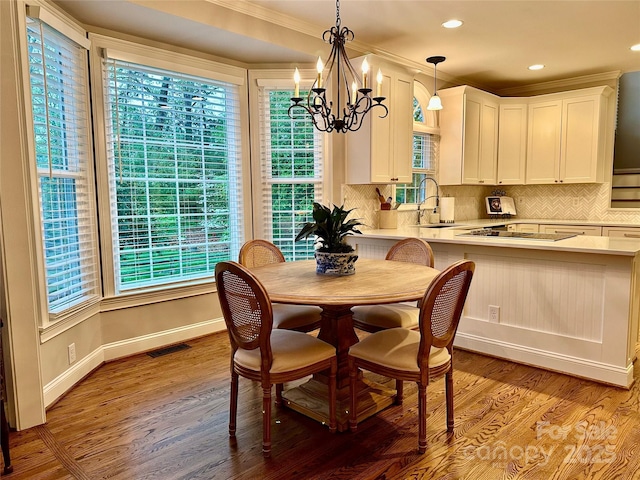 9508 Hayenridge Ct, Huntersville, NC 28078 - dining room featuring ornamental molding, light wood finished floors, an inviting chandelier, and visible vents