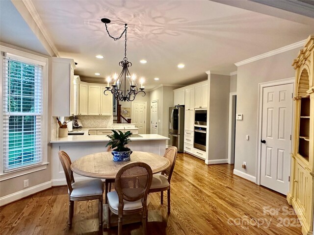 9508 Hayenridge Ct, Huntersville, NC 28078 - dining area with ornamental molding, an inviting chandelier, and wood finished floors