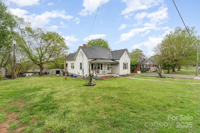 view of front of home with a front yard, a chimney, and roof with shingles