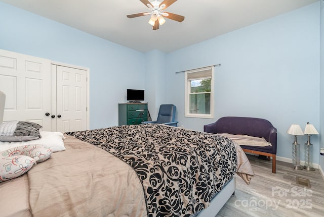 bedroom featuring a closet, baseboards, ceiling fan, and wood finished floors