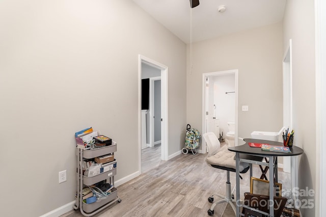 office area featuring ceiling fan, light wood-type flooring, and baseboards