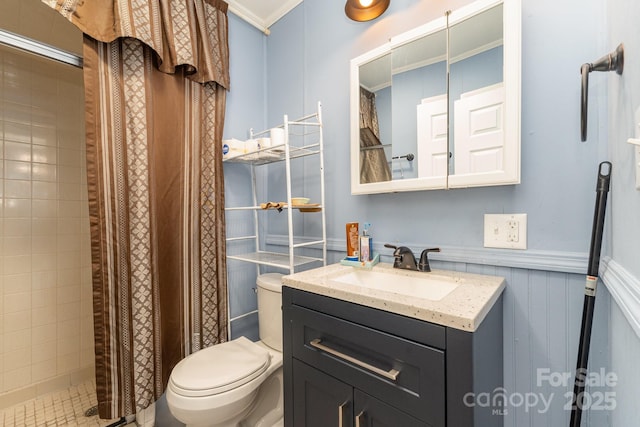 bathroom featuring vanity, ornamental molding, a tile shower, and toilet