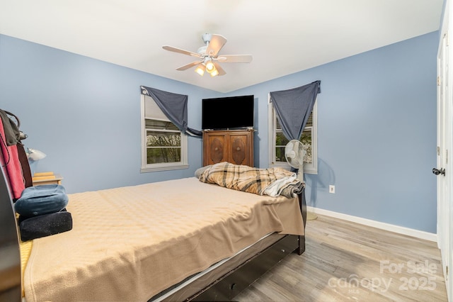 bedroom featuring wood finished floors, baseboards, and a ceiling fan