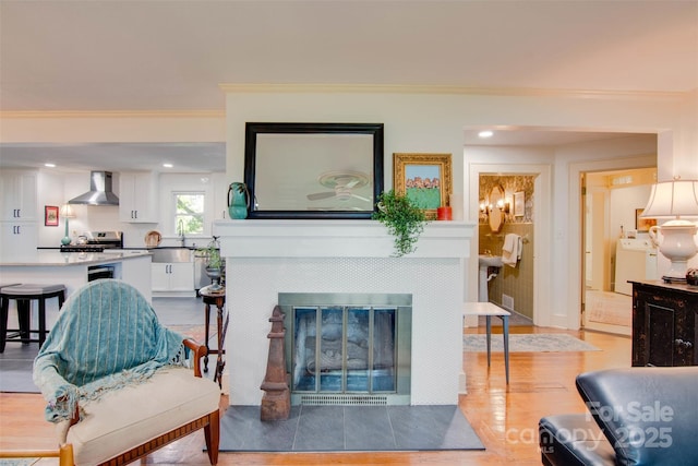 1473 12th Street Dr NW, Hickory, NC 28601 - living room featuring light wood-style flooring, a fireplace, washer / dryer, ornamental molding, and recessed lighting