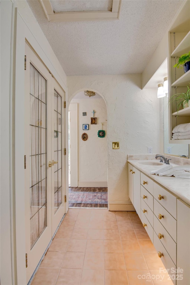 1473 12th Street Dr NW, Hickory, NC 28601 - bathroom with vanity, a textured ceiling, a textured wall, and tile patterned flooring