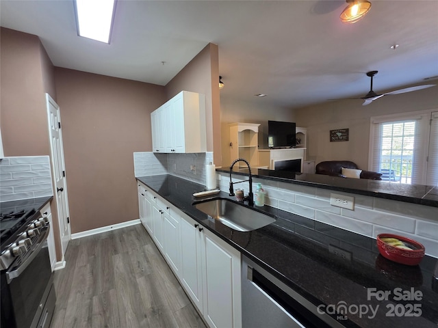 kitchen with decorative backsplash, a sink, range with gas cooktop, and dark countertops