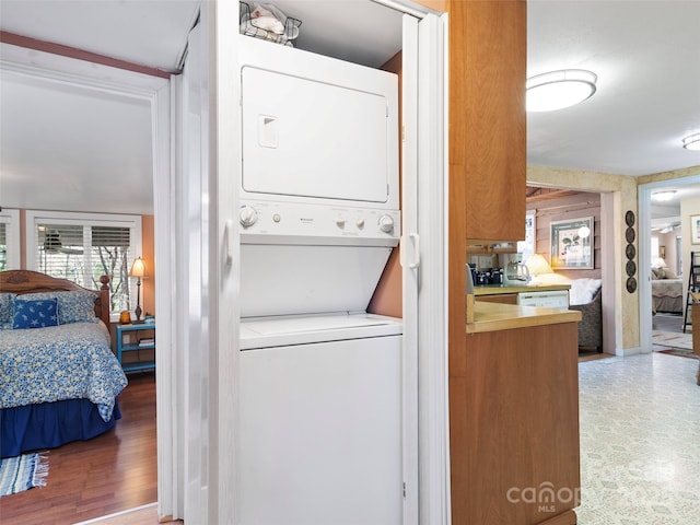 washroom with stacked washer and clothes dryer and laundry area