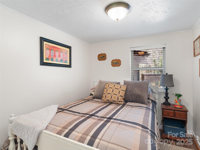 bedroom with a textured ceiling and crown molding
