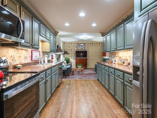 11 Bourne Ln, Asheville, NC 28803 - kitchen featuring recessed lighting, decorative backsplash, appliances with stainless steel finishes, a sink, and light wood-type flooring