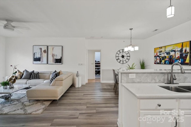 living room with wood finished floors, ceiling fan, and baseboards