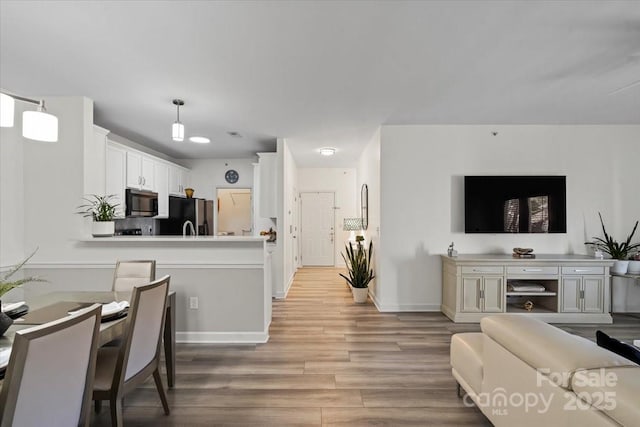living area featuring baseboards and light wood-type flooring