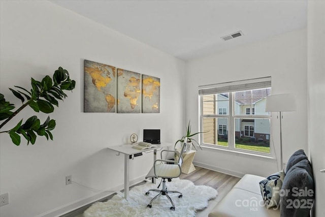 office area featuring visible vents, baseboards, and wood finished floors
