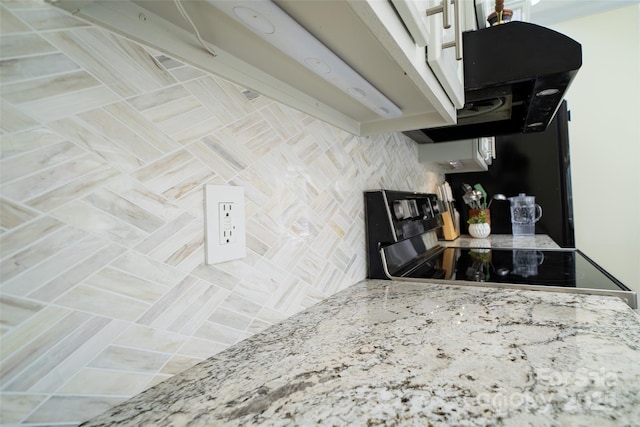 kitchen featuring range with electric stovetop and light stone counters