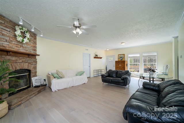 living room featuring a ceiling fan, wood finished floors, a textured ceiling, and track lighting
