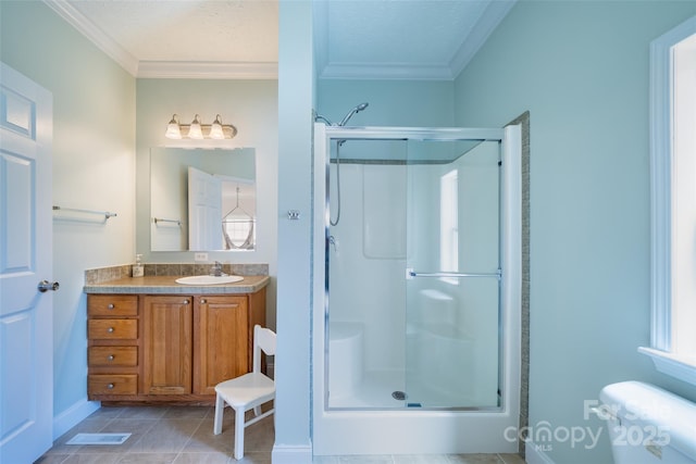 bathroom with a shower stall, crown molding, vanity, and tile patterned floors