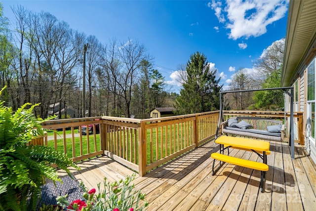 deck featuring a yard, an outbuilding, and a shed