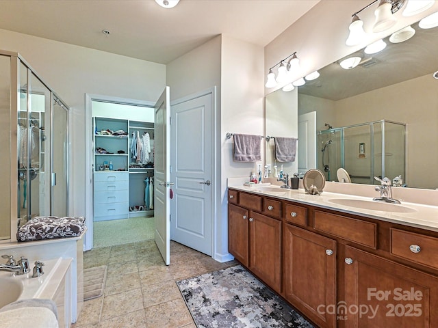 bathroom featuring a shower stall, a sink, double vanity, a garden tub, and a spacious closet