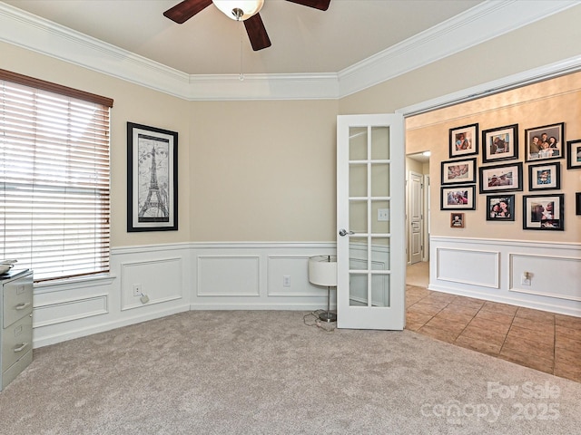 carpeted empty room featuring crown molding, a ceiling fan, and plenty of natural light