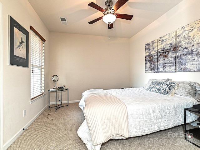 carpeted bedroom with visible vents, a ceiling fan, and baseboards