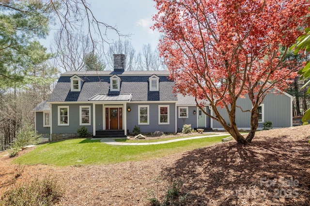 view of front of home featuring roof with shingles, a chimney, and a front lawn