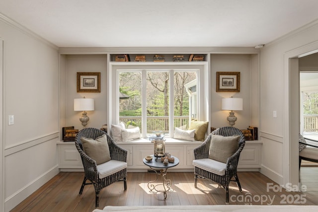 living area with hardwood / wood-style flooring and ornamental molding