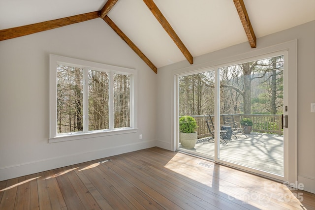 interior space with beam ceiling, visible vents, and a wealth of natural light