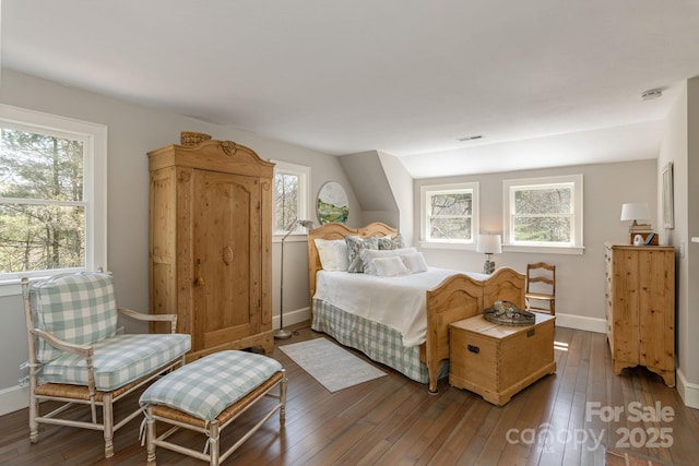 bedroom with visible vents, baseboards, and hardwood / wood-style flooring