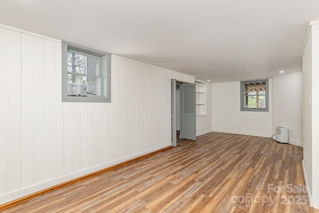 basement with baseboards and wood finished floors