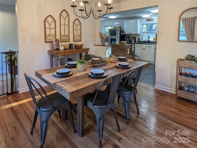 317 Balsam Dr, Waynesville, NC 28786 - dining room with dark wood-type flooring, baseboards, and an inviting chandelier