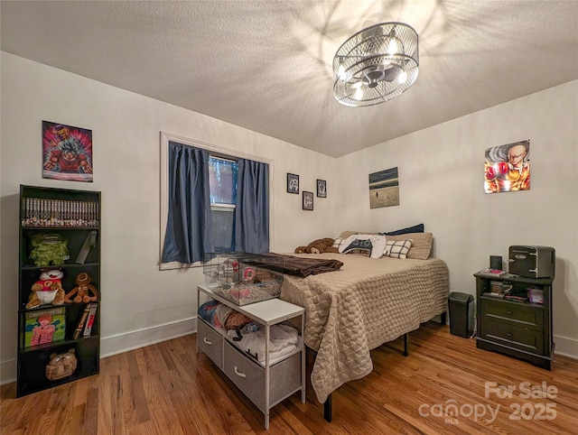 317 Balsam Dr, Waynesville, NC 28786 - bedroom featuring a textured ceiling, baseboards, an inviting chandelier, and wood finished floors