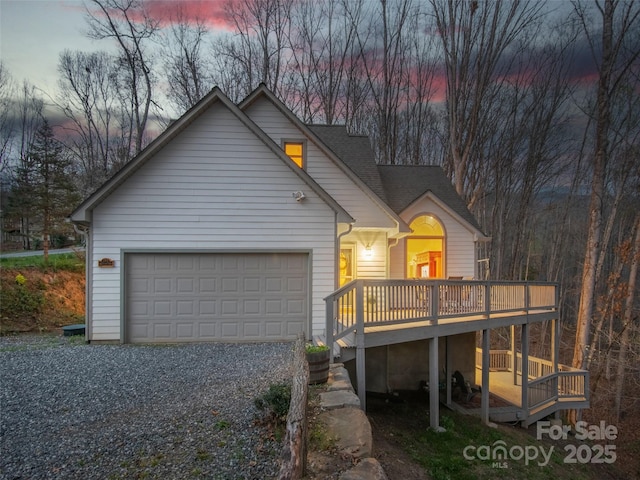 view of front of home with an attached garage, driveway, and a deck