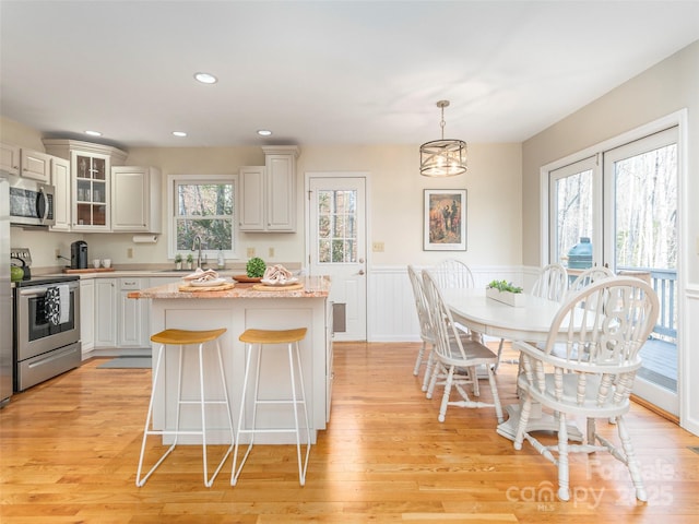 kitchen with a sink, a wealth of natural light, light wood finished floors, and stainless steel appliances