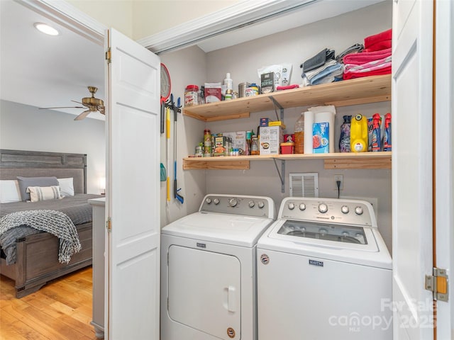 laundry room with laundry area, washing machine and clothes dryer, a ceiling fan, and light wood-type flooring