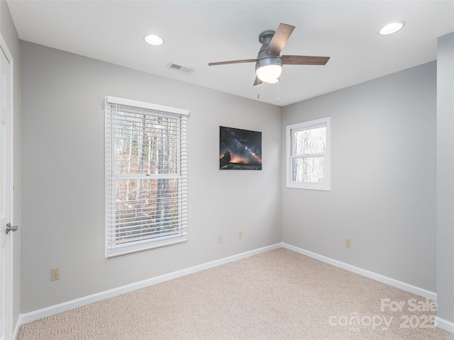 carpeted spare room featuring recessed lighting, visible vents, baseboards, and ceiling fan