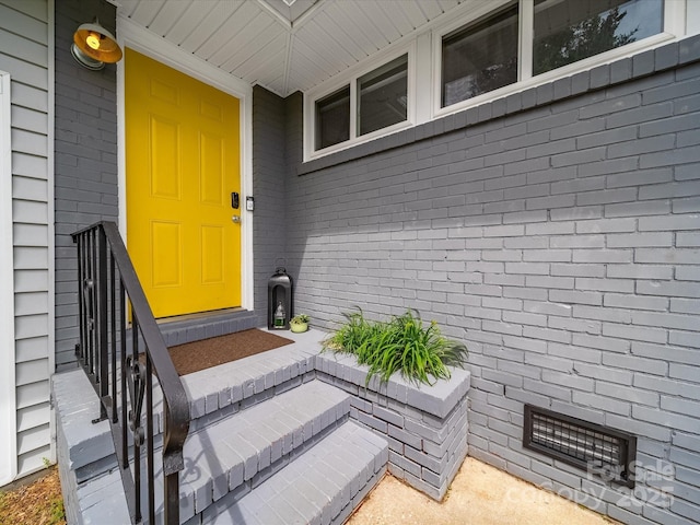 entrance to property featuring brick siding