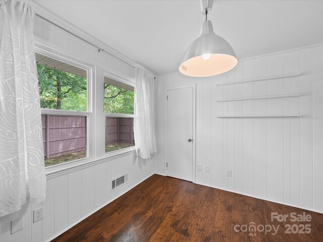 unfurnished dining area featuring visible vents and dark wood finished floors