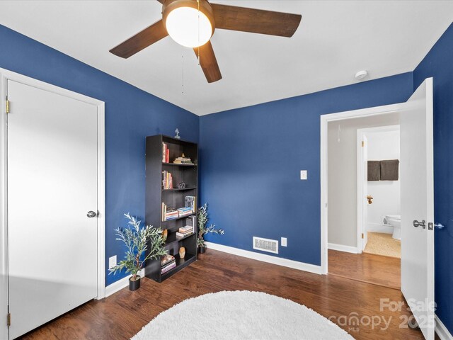 sitting room featuring baseboards, visible vents, wood finished floors, and a ceiling fan