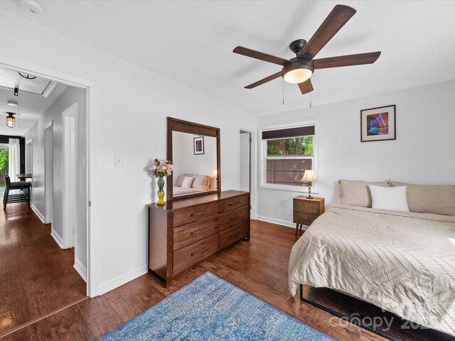 bedroom featuring attic access, dark wood-style floors, ceiling fan, and baseboards
