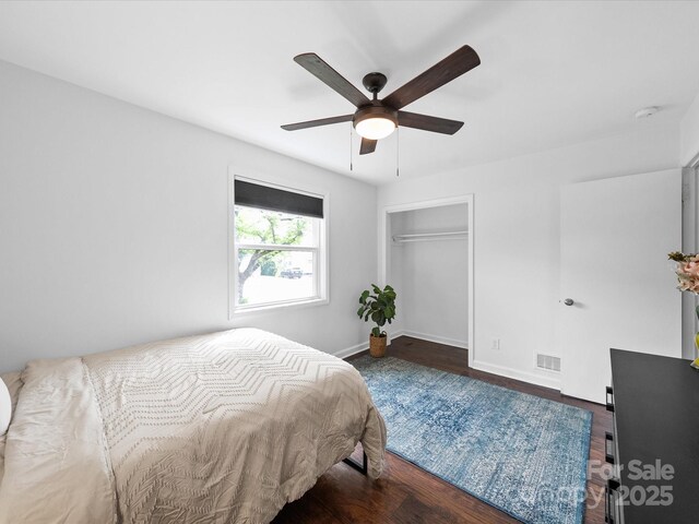 bedroom featuring visible vents, baseboards, a closet, wood finished floors, and a ceiling fan