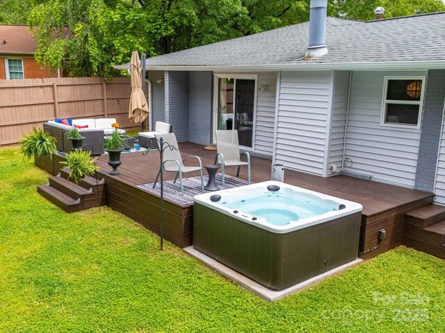 wooden terrace with a lawn, fence, a hot tub, and an outdoor hangout area