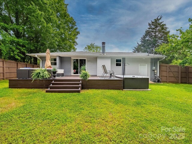 rear view of property with cooling unit, a wooden deck, a hot tub, a yard, and a fenced backyard