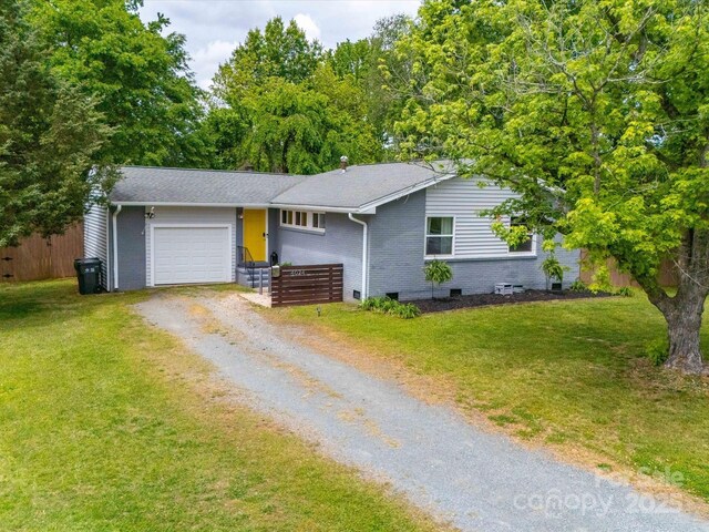 ranch-style house featuring brick siding, fence, a garage, dirt driveway, and crawl space