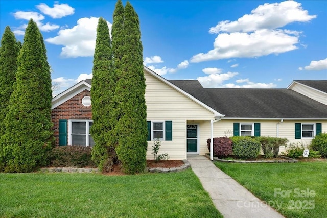 ranch-style house featuring a front yard and a shingled roof