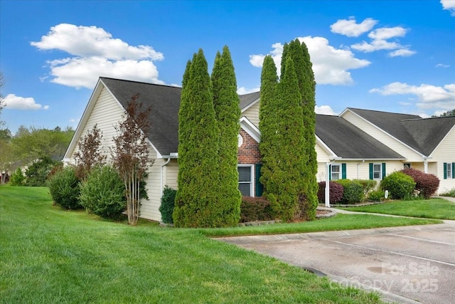 view of home's exterior featuring a yard and roof with shingles