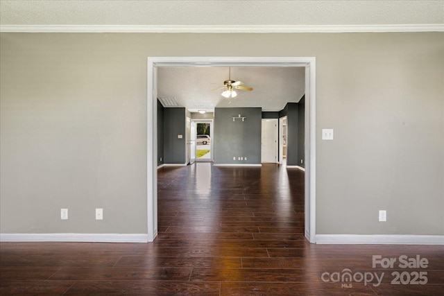spare room with crown molding, wood finished floors, and baseboards