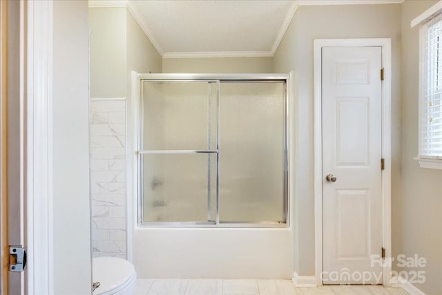bathroom with toilet, ornamental molding, and enclosed tub / shower combo