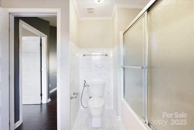bathroom featuring visible vents, ornamental molding, toilet, tile walls, and wood finished floors